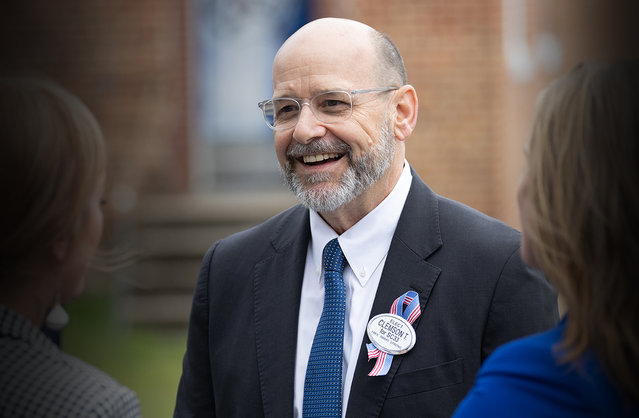 Candidate Clemson Turregano talks with people at an event.